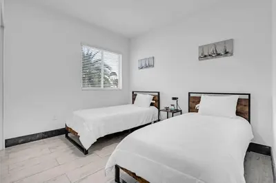 two beds in a room with white walls at Biscayne Park Villas 15450 in Miami