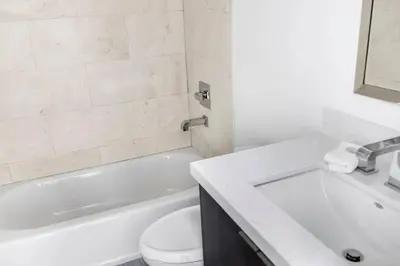 a bathroom with a white tub and a toilet and a sink at Biscayne Park Villas 15450 in Miami