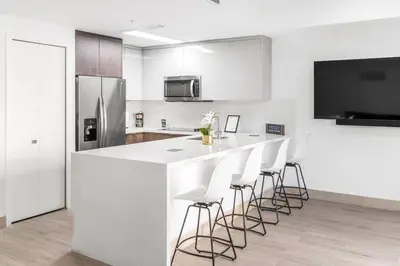 a kitchen with a bar with stools and a refrigerator at Biscayne Park Villas 15450 in Miami