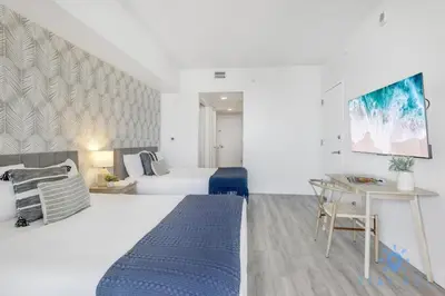 a hotel room with a bed and a desk at Modern Resort Apartment with Balcony Pool Gym in Hallandale Beach