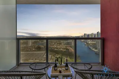 a balcony with chairs and a view of a river at Modern Resort Apartment with Balcony Pool Gym in Hallandale Beach