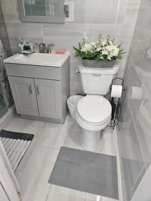 a bathroom with a toilet and a sink with flowers at Jade in Miami