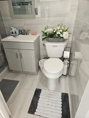 a bathroom with a toilet and a sink with flowers at Jade in Miami