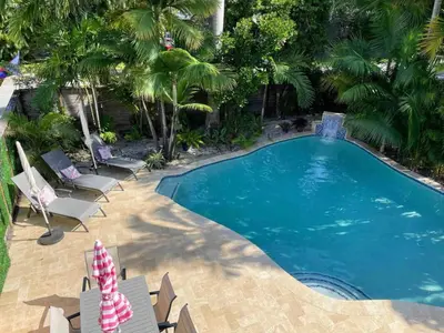 an image of a swimming pool with chairs and palm trees at 5 Minute Walk to Wilton Drive in Fort Lauderdale