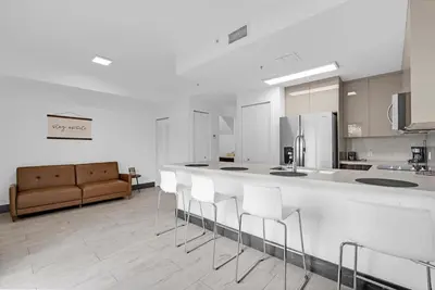 a kitchen with a bar with chairs and a couch at Biscayne Park Villas 15440 in Miami