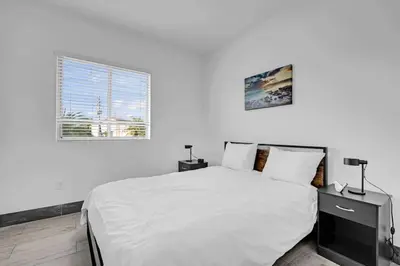 a white bedroom with a bed and a window at Biscayne Park Villas 15440 in Miami