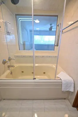 a bathroom with a shower and a tub with a window at D' Mauchi Waterfront House in Miami
