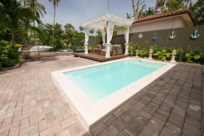 a swimming pool in a backyard with a gazebo at D' Mauchi Waterfront House in Miami