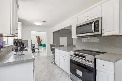 a kitchen with white cabinets and a microwave at Spacious 3BR Villa in Miami with Fenced Backyard in Miami