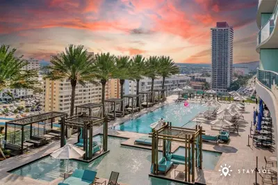 a pool on the top of a building with palm trees at Hollywood Beachfront Apt Amazing View & Amenities in Hollywood