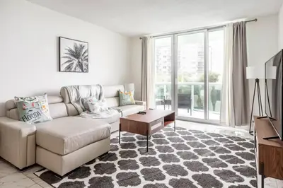 a living room with a couch and a table at Beachfront, Pools, Patio, King Bd Villa- Hollywood FL in Hollywood