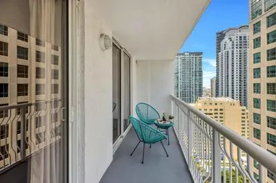 a balcony with a blue chair and a table at Confortable Apartment with pool and gym in Miami