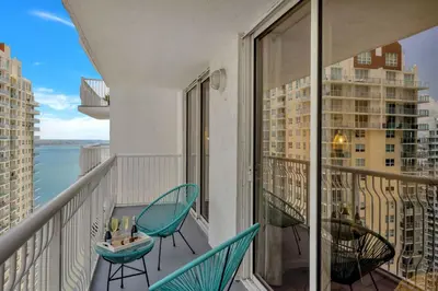 a balcony with two chairs and a table at Confortable Apartment with pool and gym in Miami