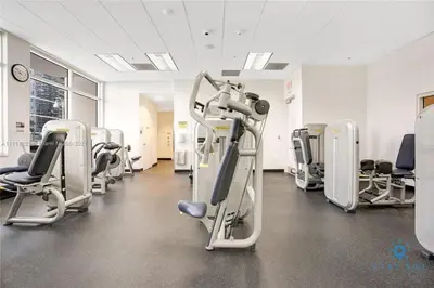a gym with rows of treadmills and ellipticals at Confortable Apartment with pool and gym in Miami
