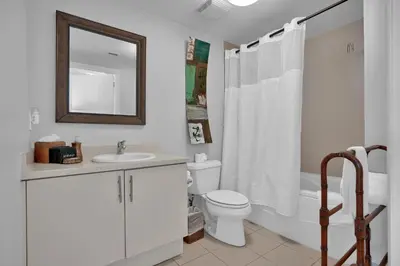 a bathroom with a toilet and a sink and a mirror at Astonishing SEA VIEW Studio in Grove in Miami