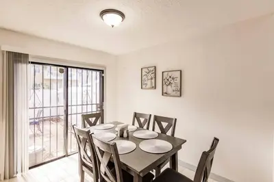 a dining room with a table and chairs and a window at Miami Oasis 7 mins to Dolphin Mall MIA PS4 Games in Miami