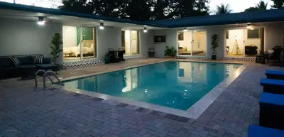 a swimming pool in a yard with a house at Villa Tropical - Your private Miami Resort with a heated pool in North Miami