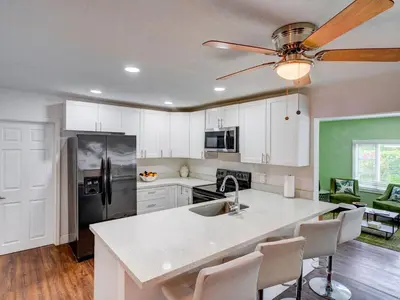 a kitchen with white cabinets and a sink and a refrigerator at Luxury Miami Casa Bonita with Tropical Pool Oasis in Miami