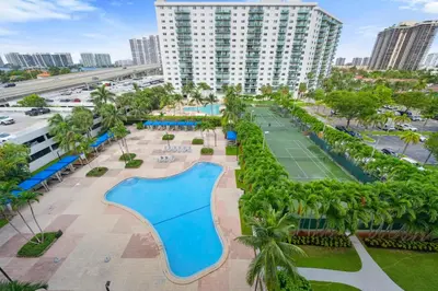 an aerial view of a resort with a pool and tennis courts at Beautiful and big Apartment by the beach in Sunny Isles Beach