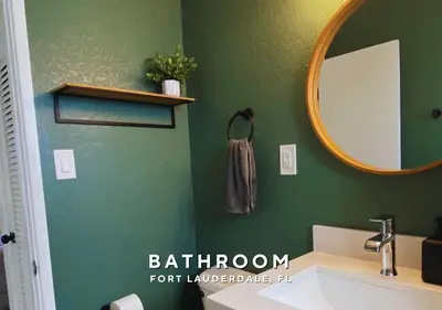 a green bathroom with a sink and a mirror at Private Heated Plunge Pool Spa and Secluded Patio - Fort Lauderdale in Fort Lauderdale