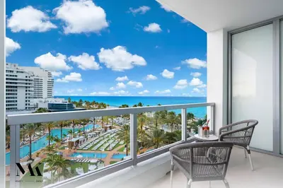 a balcony with a view of the beach and ocean at FountaineBleau Resort, Balcony with Ocean & Pool View in Miami Beach