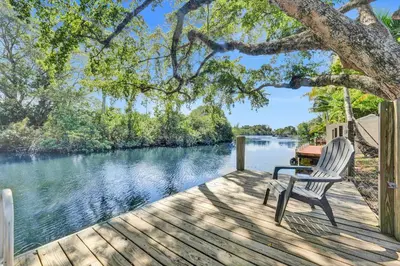 a wooden deck with a chair sitting on it next to a river at Private Waterfront Paradise in Hollywood