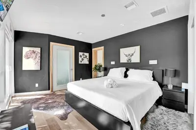 a bedroom with a large bed with black walls at Private Waterfront Paradise in Hollywood