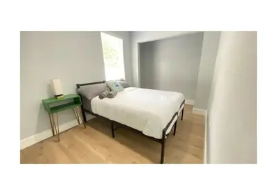 a small bedroom with a bed and a table at Cozy Duplex near Wynwood & Beach in Miami