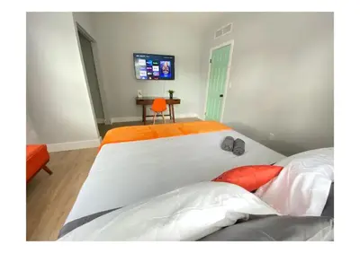 a bedroom with two beds and a tv on the wall at Cozy Duplex near Wynwood & Beach in Miami