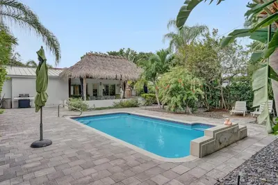 a swimming pool in front of a house at Daddy House-victoria Park With Pool in Fort Lauderdale