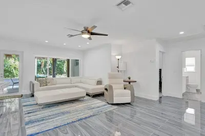 a living room with white furniture and a ceiling fan at Daddy House-victoria Park With Pool in Fort Lauderdale