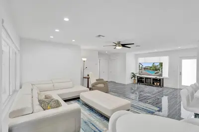 a living room with white furniture and a ceiling fan at Daddy House-victoria Park With Pool in Fort Lauderdale