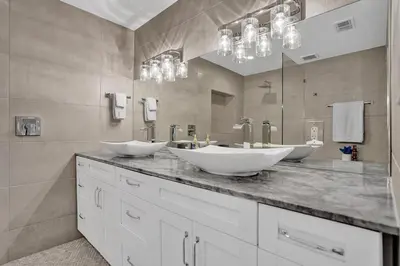 a bathroom with two sinks and a large mirror at New ! Pool House 3-bedroom Home Victoria Park in Fort Lauderdale