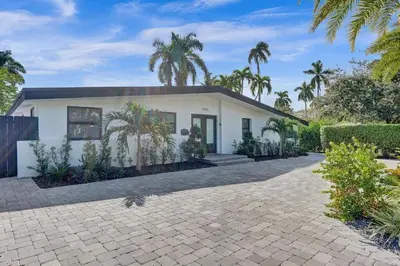 a house with palm trees in front of it at New ! Pool House 3-bedroom Home Victoria Park in Fort Lauderdale