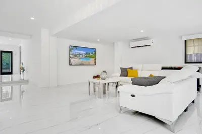 a white living room with a white couch and a table at Hibiscus House in Fort Lauderdale