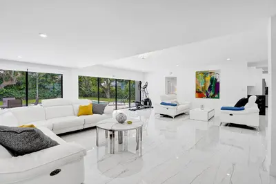 a white living room with white furniture and windows at Hibiscus House in Fort Lauderdale