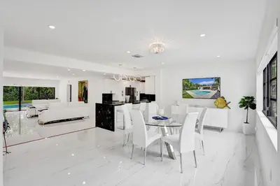 a white living room with a table and white chairs at Hibiscus House in Fort Lauderdale
