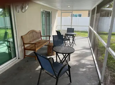 a porch with chairs and tables and a bench at waterfront Ocean dream House Hollywood Hard Rock airport in Fort Lauderdale
