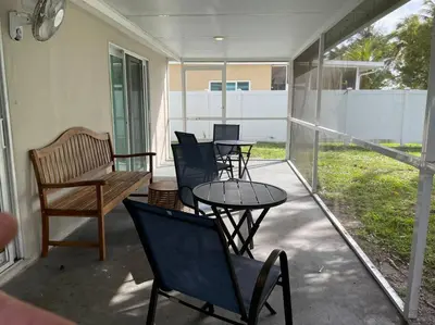 a porch with chairs and a table and a table and chairs at waterfront Ocean dream House Hollywood Hard Rock airport in Fort Lauderdale