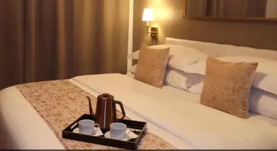 a tray with cups and a tea kettle on a bed at Hotel Downtown Miami - DQR in Miami