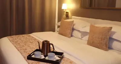 a tray with a tea kettle and cups on a bed at Hotel Downtown Miami - DQR in Miami