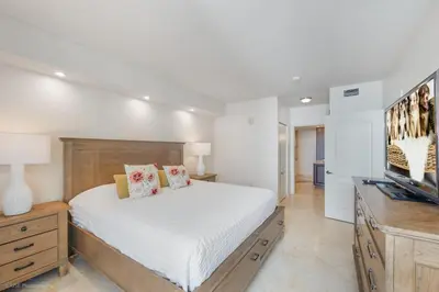 a bedroom with a bed and a flat screen tv at Modern 2 BDR at King David with Ocean View in Sunny Isles Beach