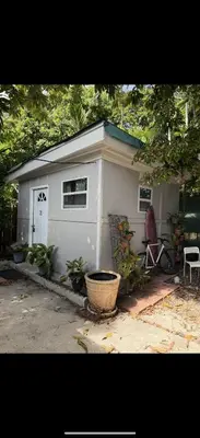 a small white shed with a basket in front of it at Tiny house WiFi and parking in Miami