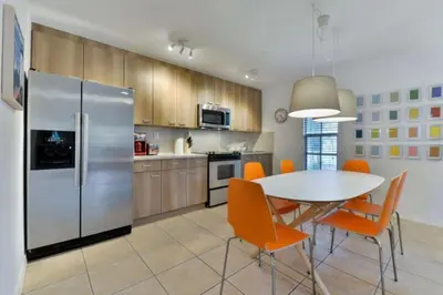 a kitchen with a table and a refrigerator at Wynwood Area with Hot Tub, 10 min from South Beach in Miami