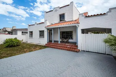 a white house with a white fence at West Brickell GEM With Private Garden, 2BR 2BATH in Miami