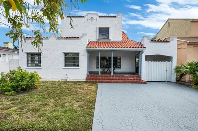a white house with a driveway in front of it at West Brickell GEM With Private Garden, 2BR 2BATH in Miami