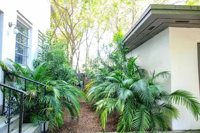 a garden with palm trees next to a building at 3 Bedroom Apartment with BBQ and Patio, Near Brickell in Miami