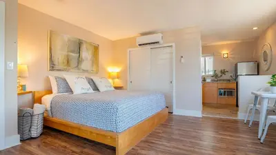 a bedroom with a bed and a kitchen with a refrigerator at Winter Rate Discount Beachside Home Pool Views Beach Haven by AvantStay in Fort Lauderdale
