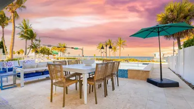 a table with chairs and an umbrella on a patio at Winter Rate Discount Beachside Home Pool Views Beach Haven by AvantStay in Fort Lauderdale
