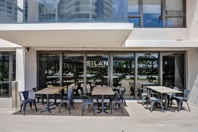 a restaurant with tables and chairs in front of a building at Beautiful Oceanfront 3BDR Condo 801 in Miami Beach